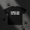 Black heavyweight tee with bold white 30 DROPS LATER STILL NOT DONE typography